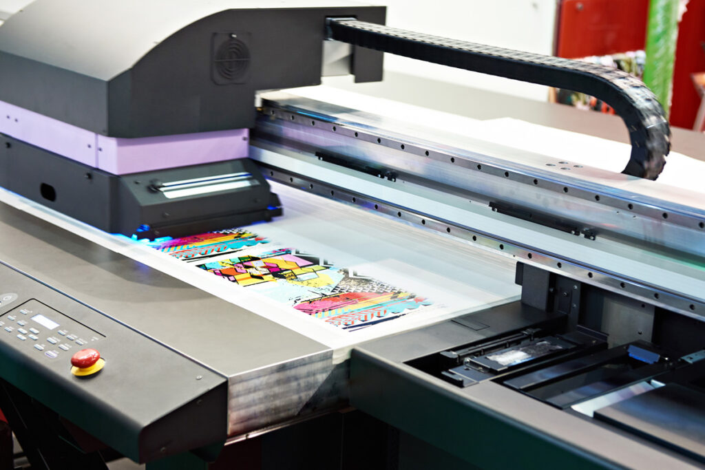 A sticker printing machine creating colorful stickers for an El Paso business.