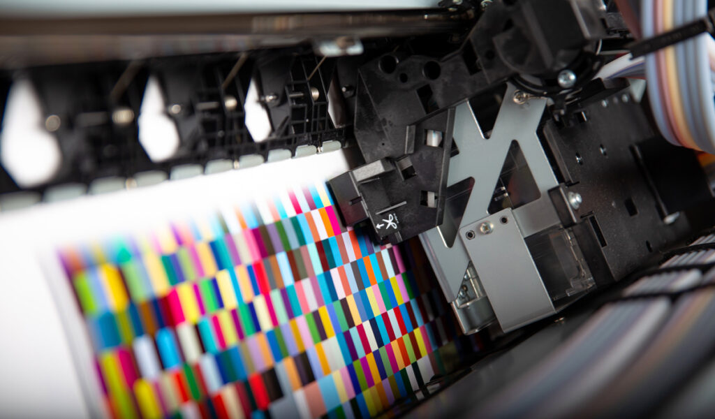 An industrial printer printing a piece of paper with colorful squares in El Paso.