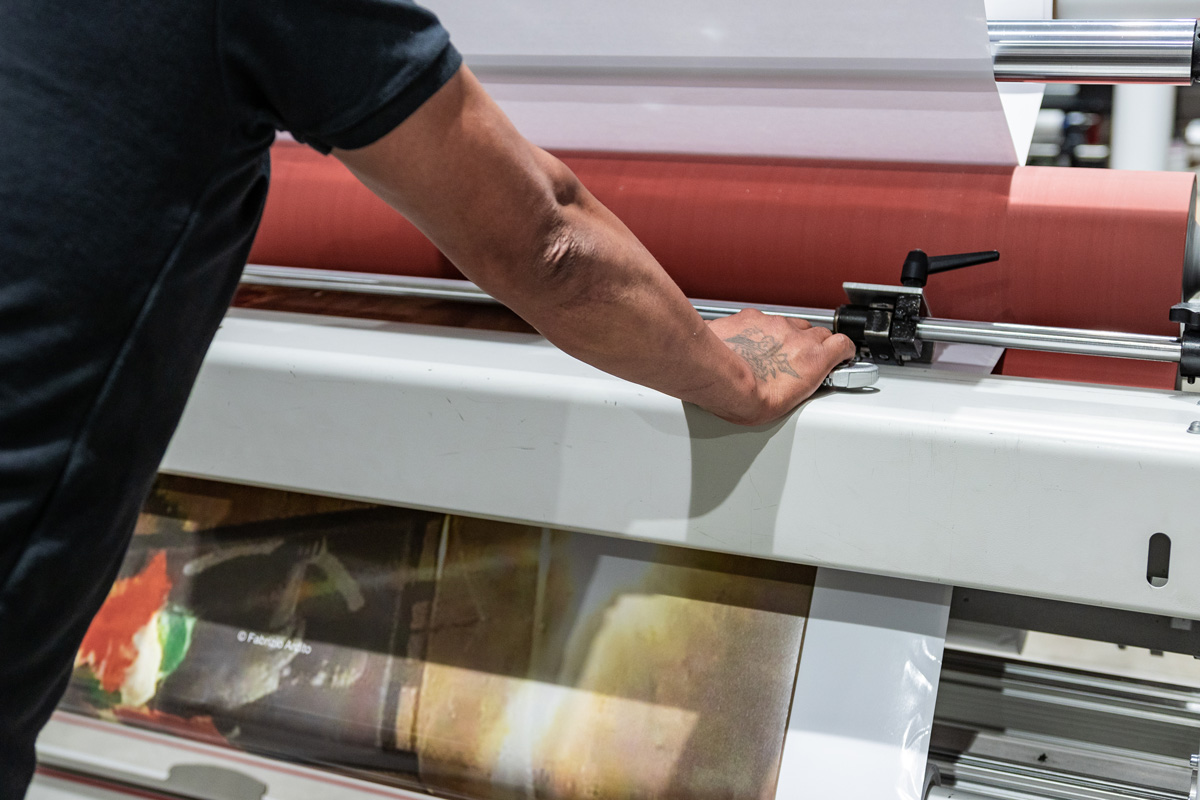 A person using a red and white industrial printer in El Paso.